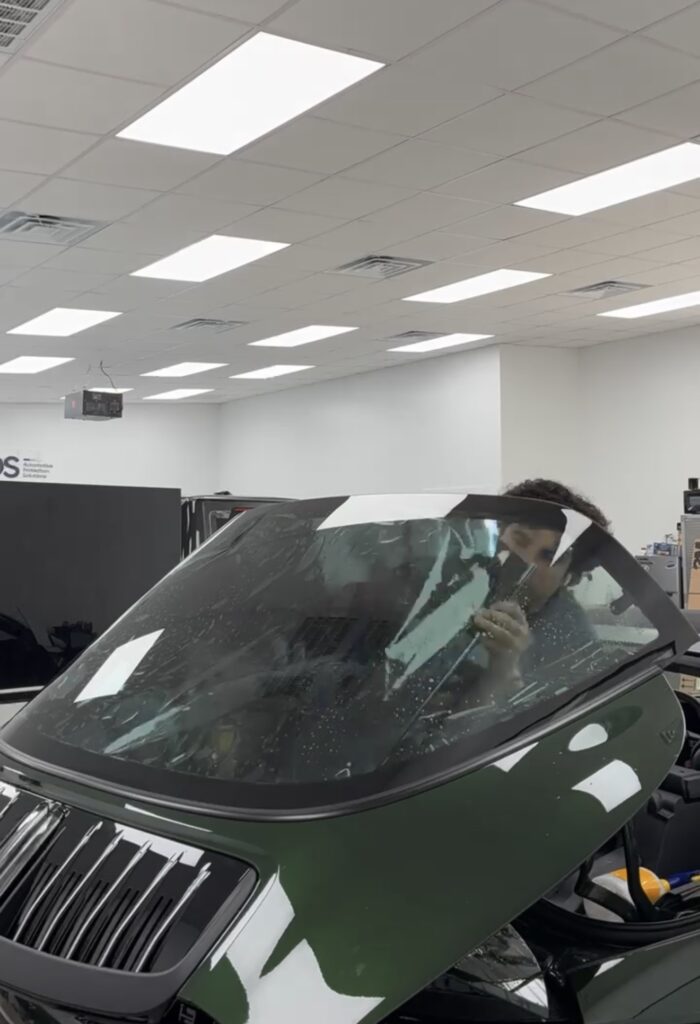 Installer laying window tint film on the inside of the Porsche 911 Targa 4S rear glass at APS in Austin, TX