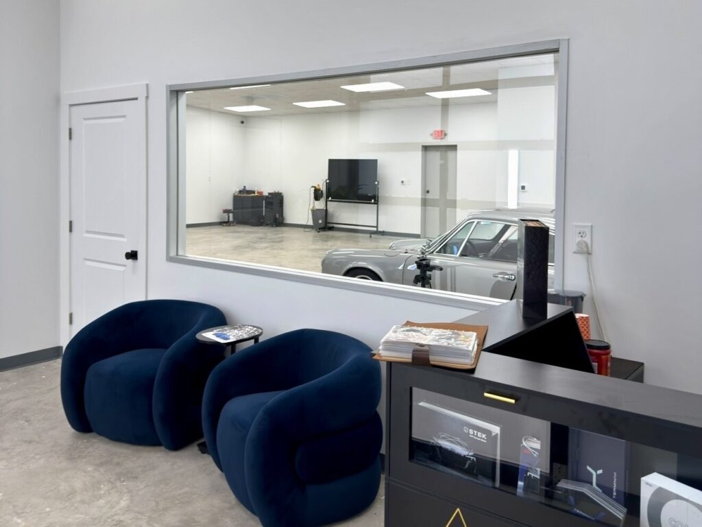 Customer lounge at APS with a large window looking directly into the install bay