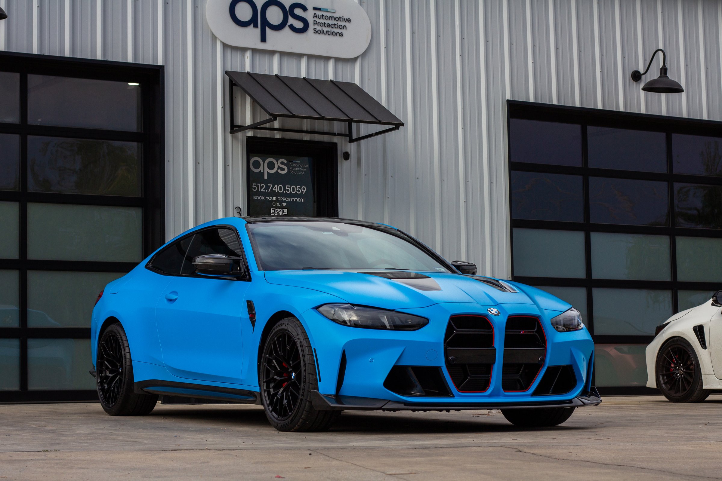 BMW M4 with matte blue PPF in front of the APS Automotive Protection Solutions shop in Austin, TX