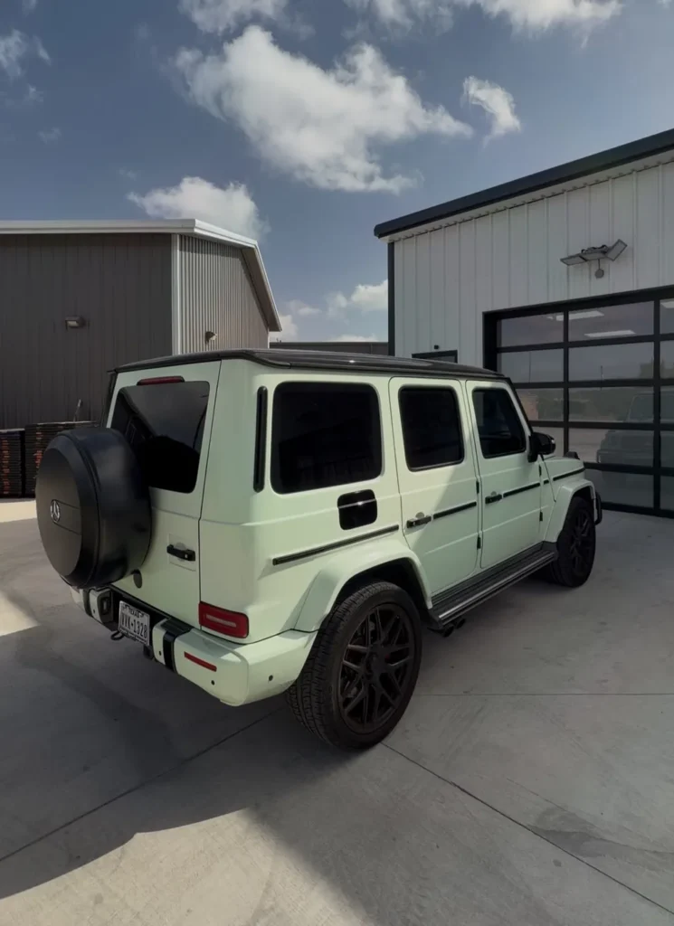 Rear view of the green vinyl wrapped Mercedes G63 before wrap removal