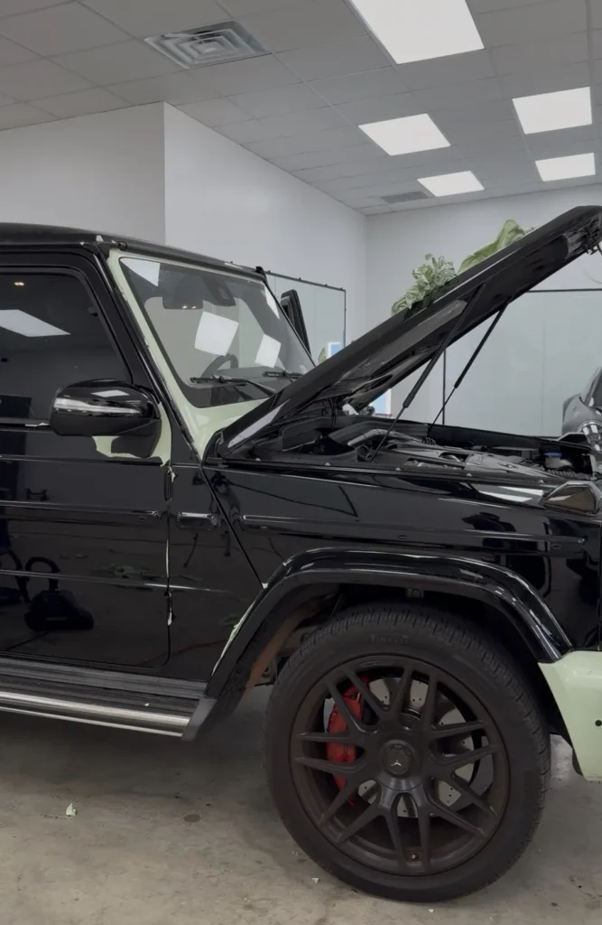 Mercedes G63 halfway through vinyl wrap removal showing original black paint